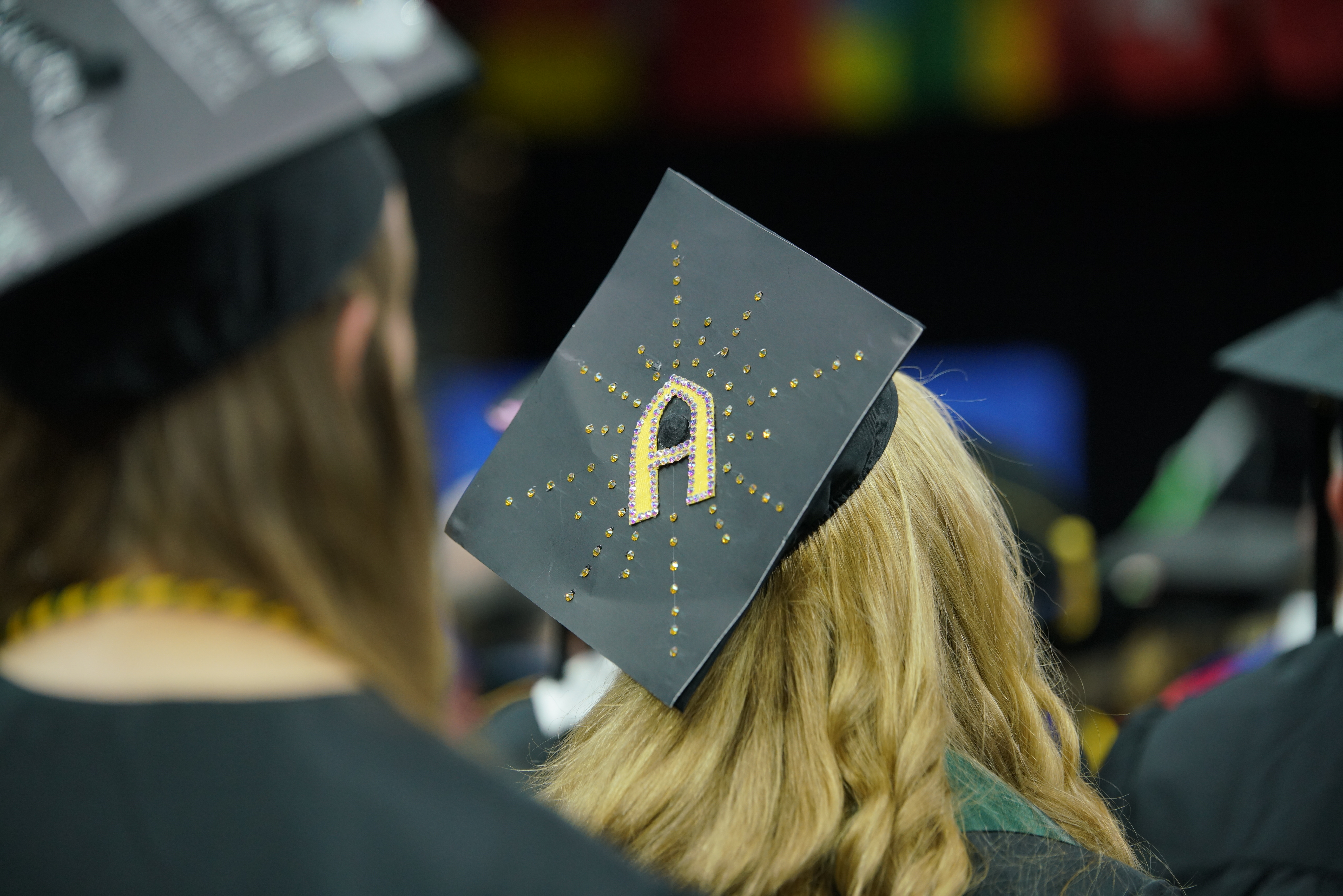 Black graduation cap with a yellow 'A'