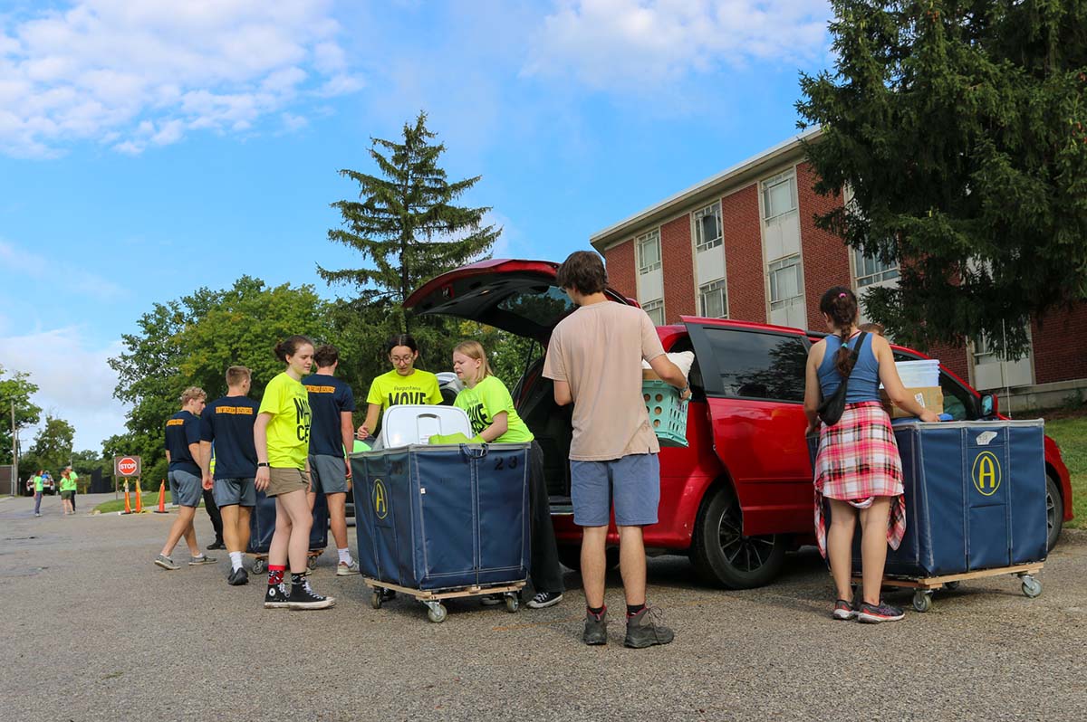 students loading a cart at move in