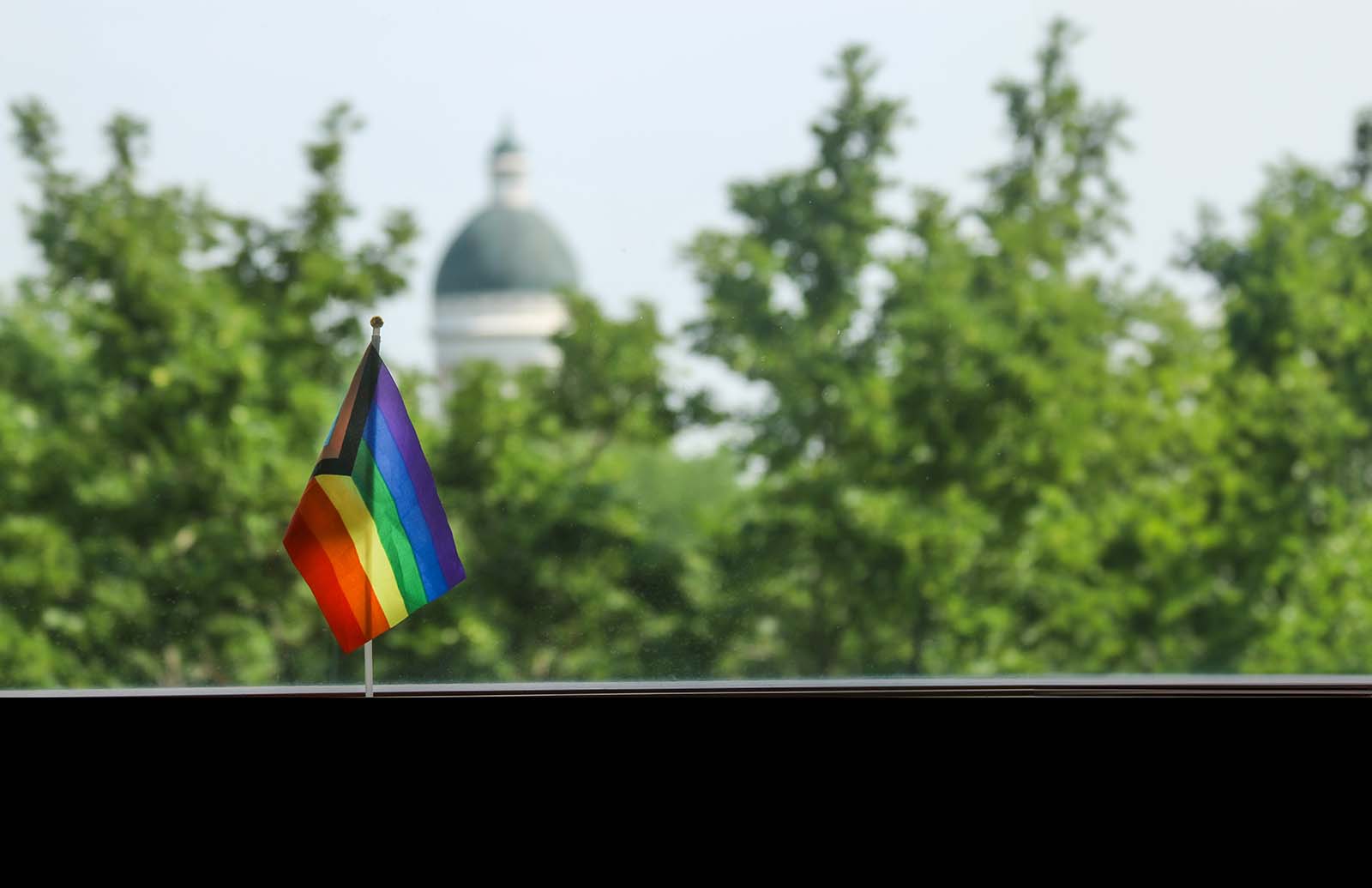 Pride flag with iconic Old Main in the background