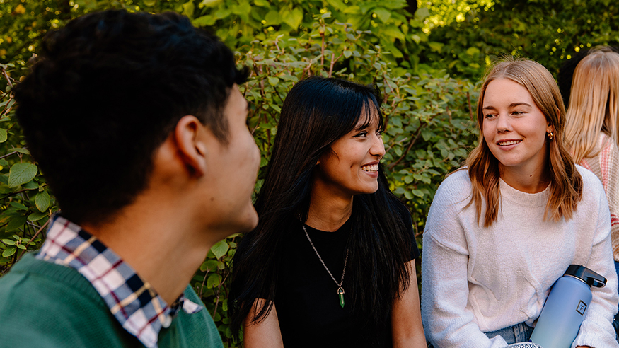 A diverse group of students talking outside