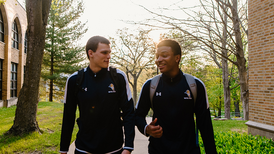 Two student-athletes walking through campus