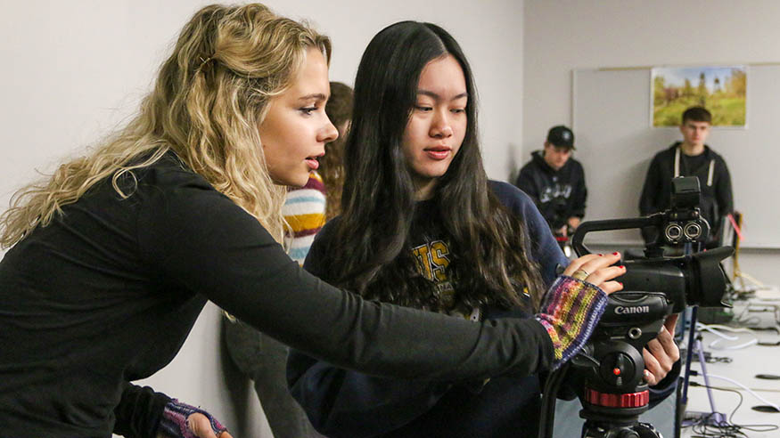  Two students reviewing film footage in a camera