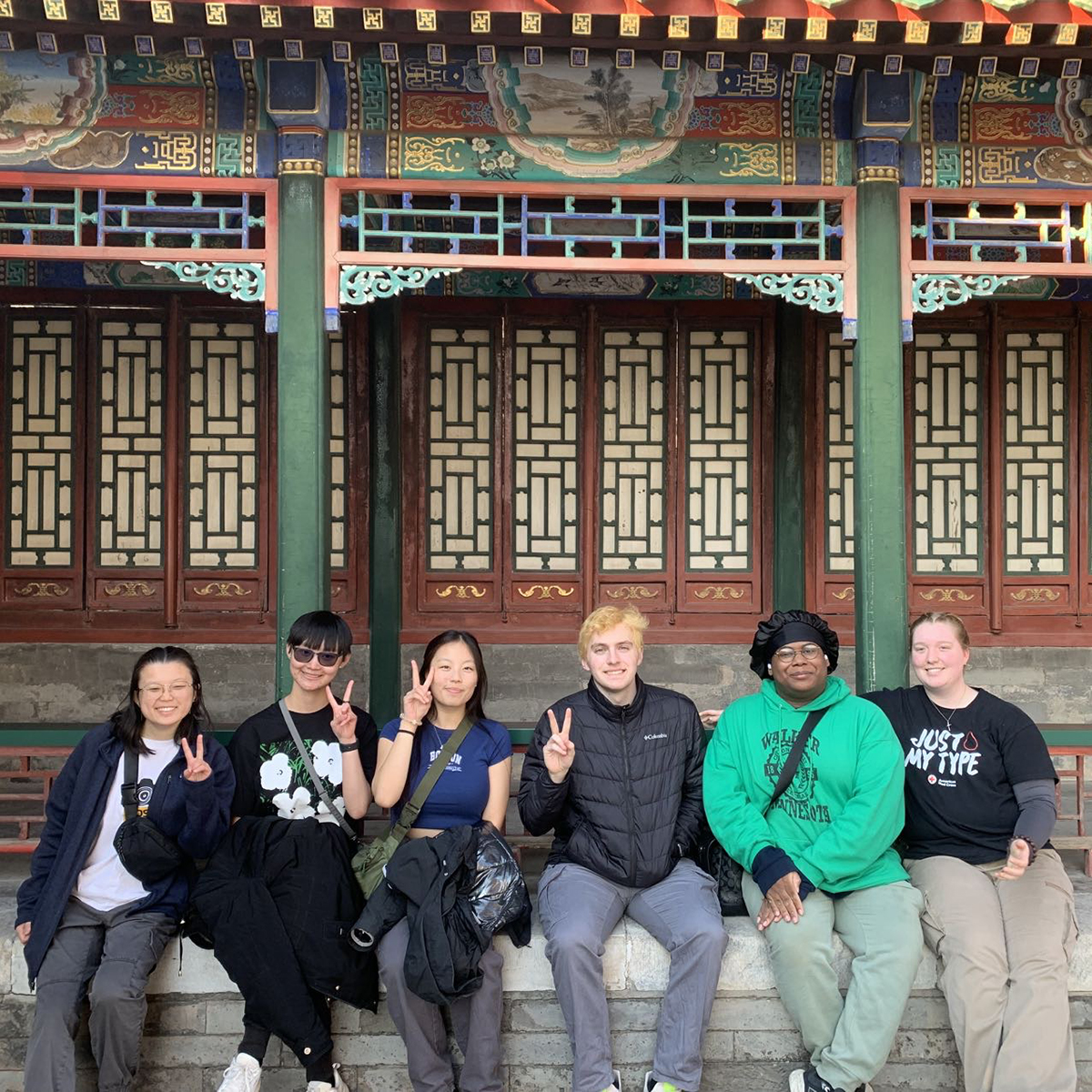 A group of students pose in front of a palace