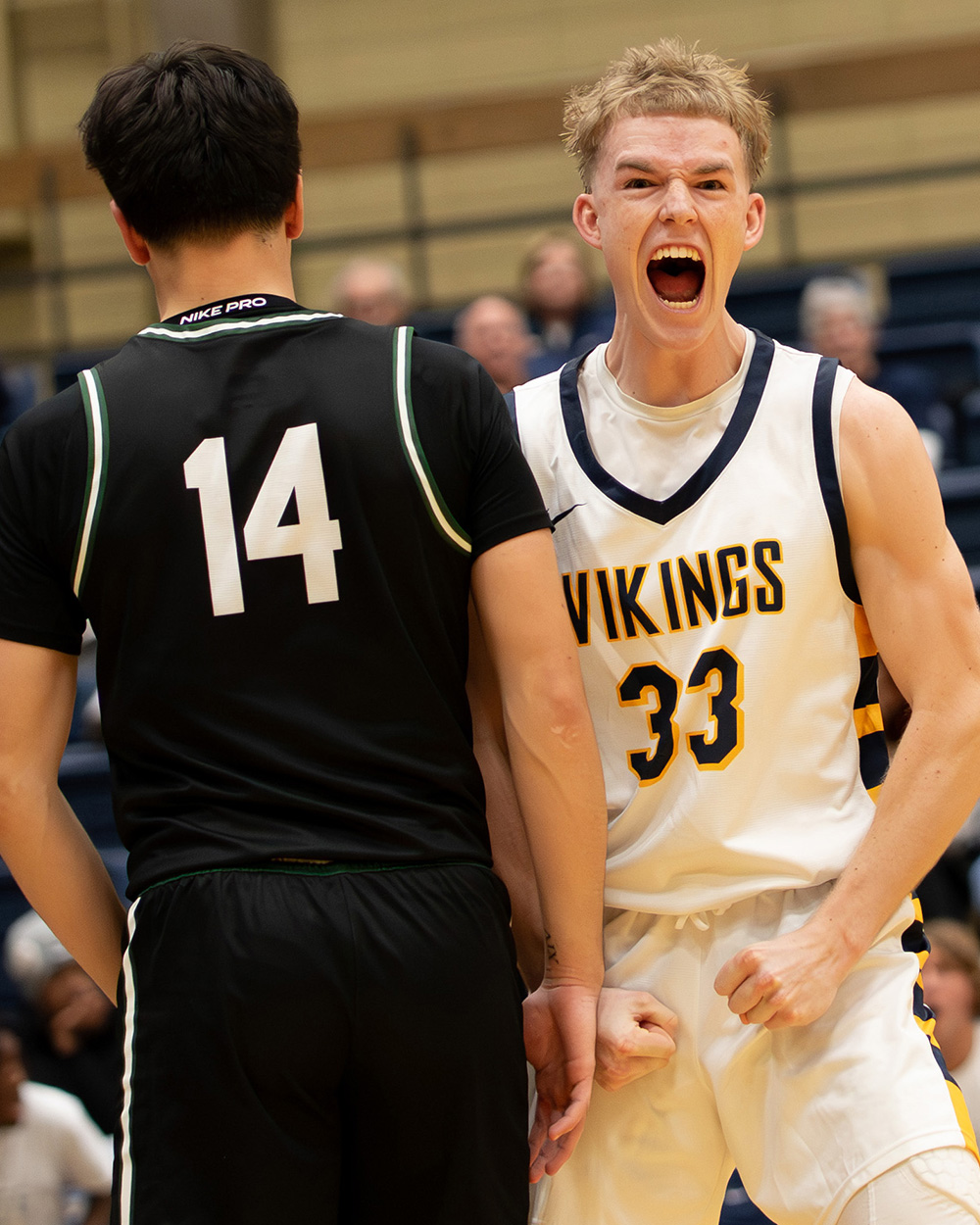 An Augustana basketball player shouts in celebration
