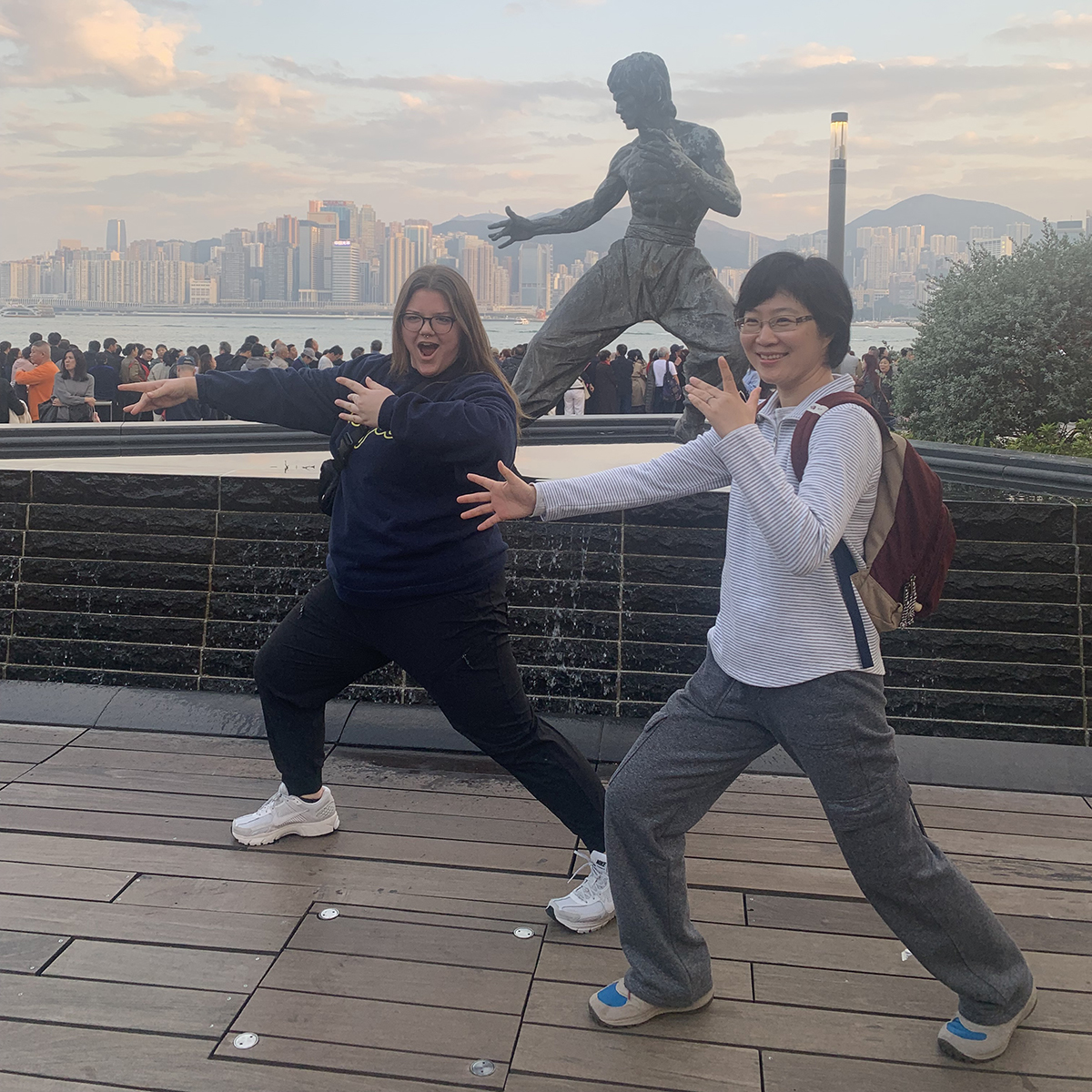 Two people posing with a statue