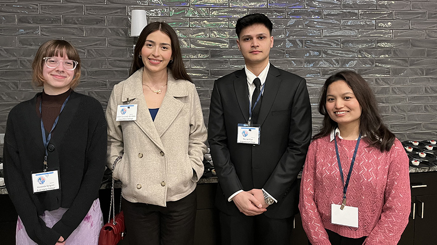 Four students in front of a gray backdrop