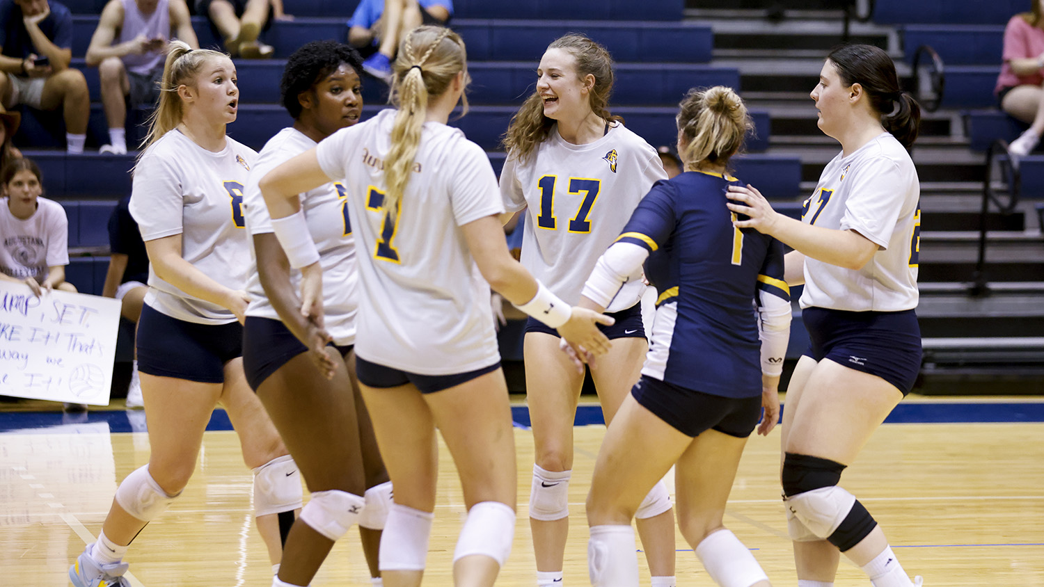 The women's volleyball team huddles up during a match