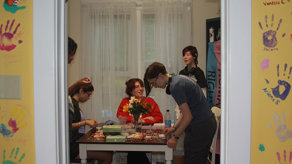 Students talk inside a house