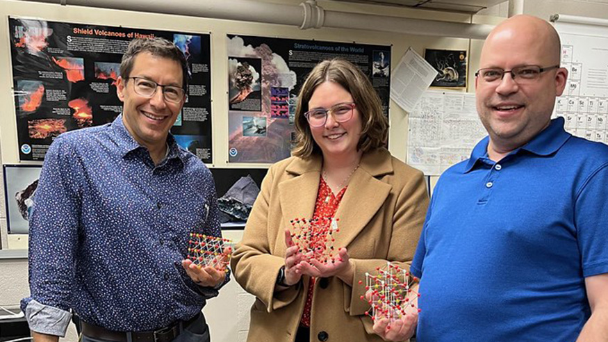Two faculty members and a guest lecturer, each holding a physics toy
