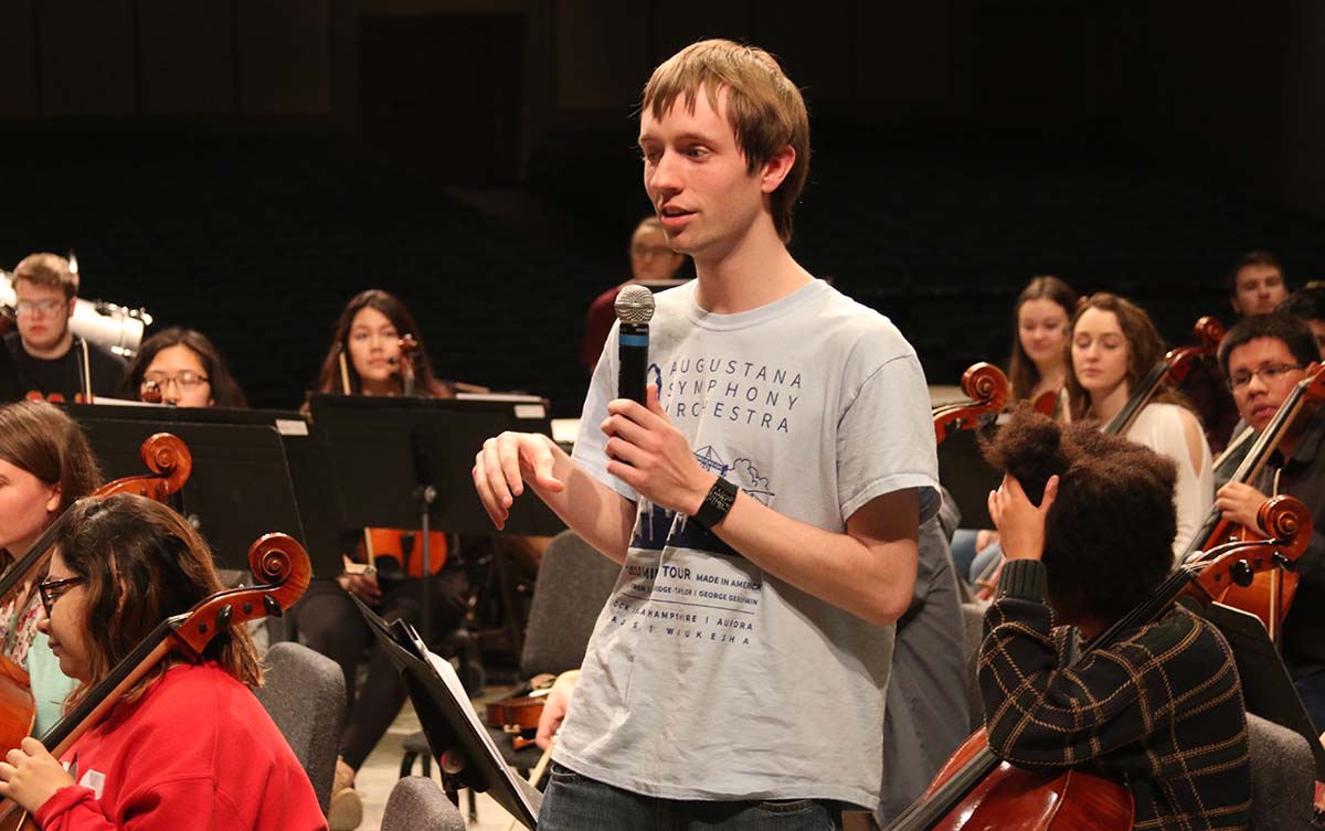 Gabriel Lance '19 presenting with a group on student orchestral compositions.