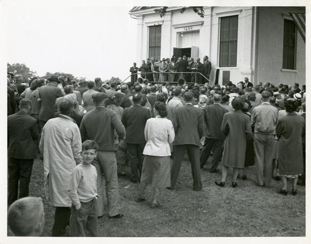 Official Swedish Delegation of the Swedish Pioneer Centennial gathered on the stoop of the Jenny Lind Chapel in Andover, Illinois, 1948. From the Allan Kastrup collection, Swenson Swedish Immigration Research Center.