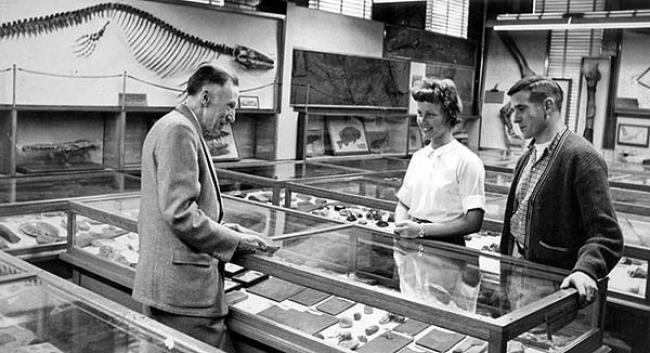 Jan. 1971, Fritiof Fryxell shows specimens to two students in the museum in Wallberg Hall. (Augustana Special Collections)