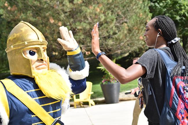 Gus gives a student a high-five.