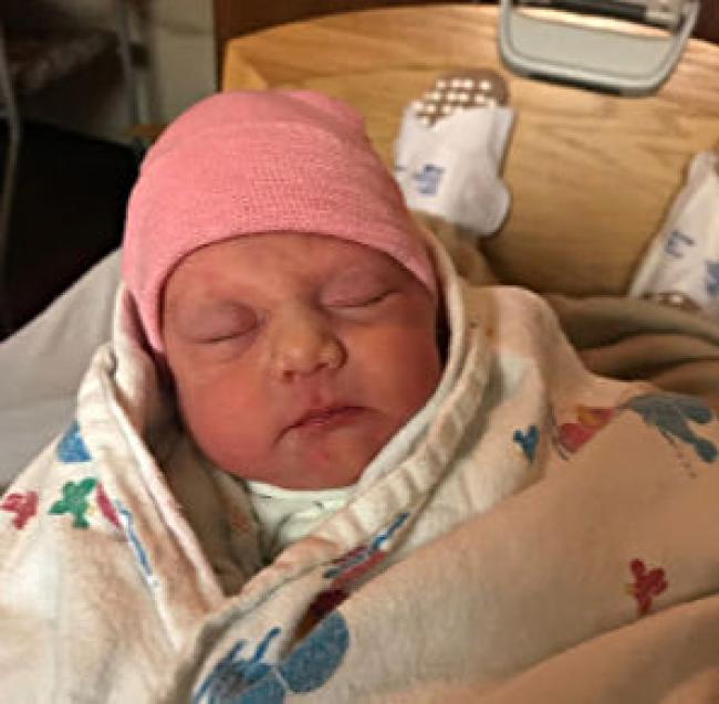 photo of baby Anna Marie wrapped in a cozy blanket with a pink hat