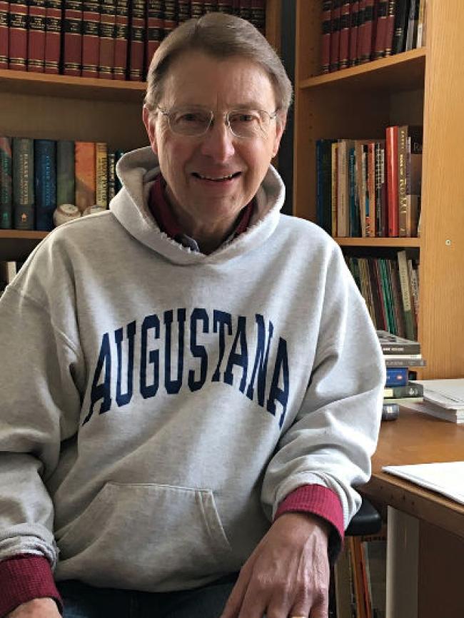 Pastor Priggie in a library wearing an Augie shirt.