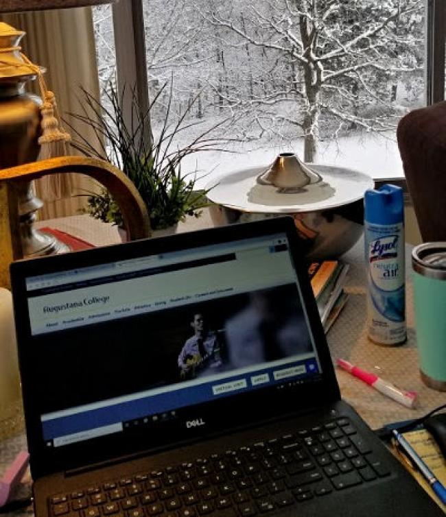 Winter snow in the background with lysol can and laptop. Lamp in the left corner.