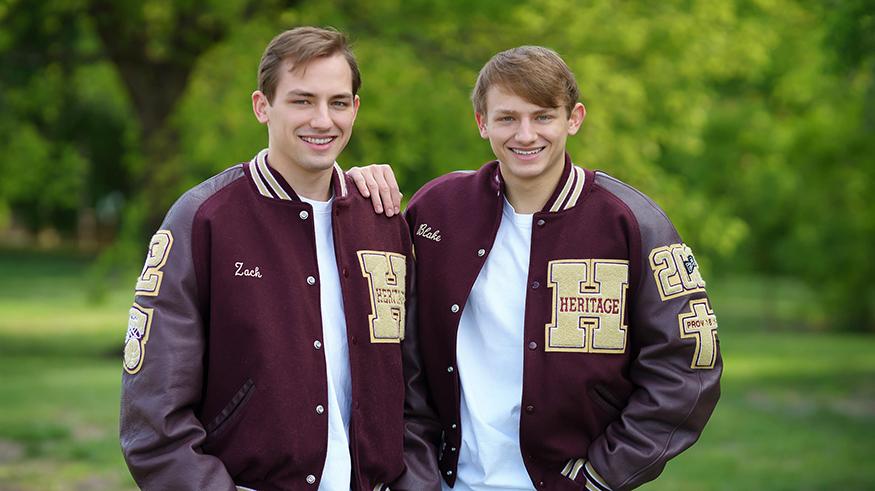 Twins Zach and Blake Benn pose for a photo in letterman's jackets. 