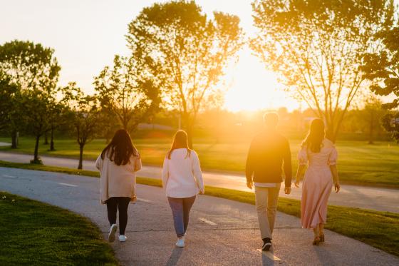 four students walking into the sunset