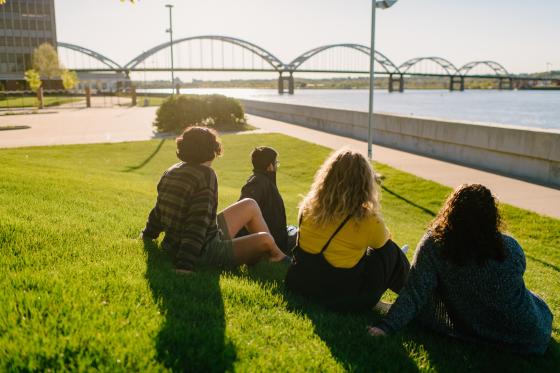 students smiling looking over there river front with a bridge in the background