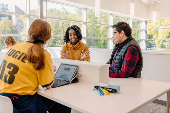 Three student studying at a white table