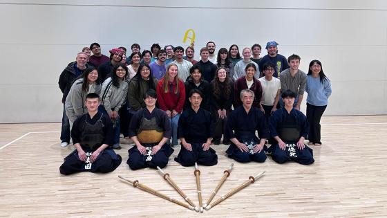 A group of students and instructors posing in a classroom Japan